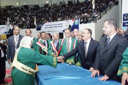 رئيس الجمهورية يصافح إحدى المكرمات في يوم العلم/ أمس